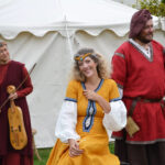 Trois artistes en costumes médiévaux avec guitare et instrument à archet lors du spectacle