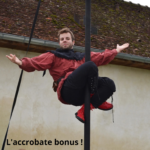 Jongleur acrobate en costume médiéval réalisant une figure autour d’un mât